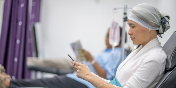 Un paciente oncológico que mira el teléfono en el hospital