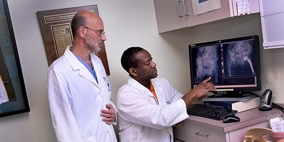 Dos médicos examinando una radiografía de cadera