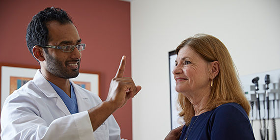 Un médico que levanta un dedo para evaluar el progreso de un paciente después de un accidente cerebrovascular