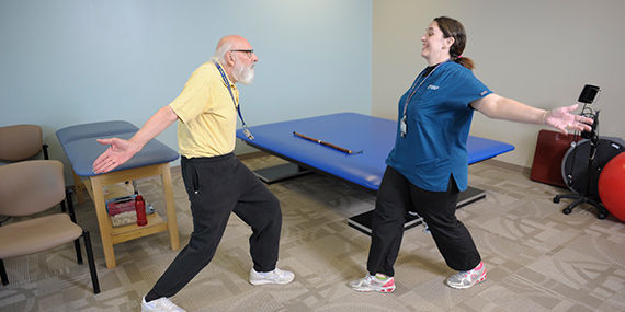 Un terapeuta que orienta a un paciente que tiene Parkinson con ejercicios de la terapia LSVT BIG