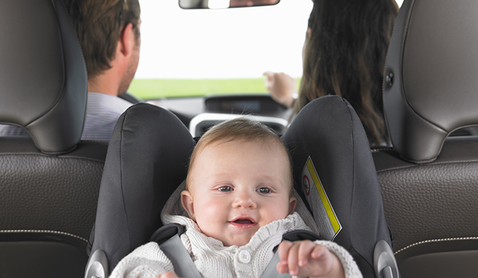 Bebé seguro y feliz en un asiento para automóvil