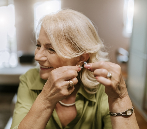  Senior woman playing with hearing aid
