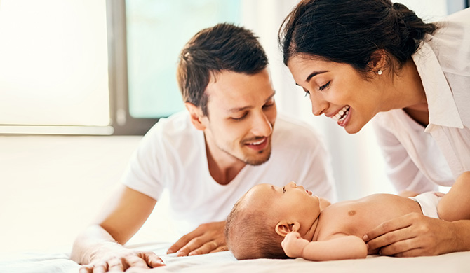 Mother and father smiling with baby