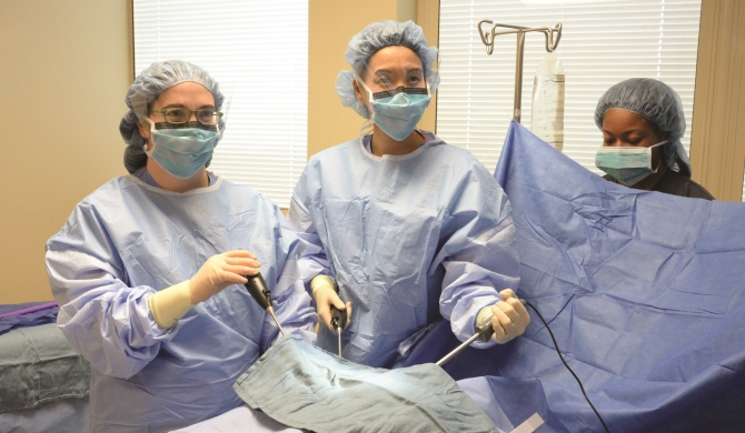 Female surgeons in scrubs performing surgery