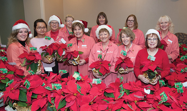 A group of Junior Board members holding poinsettas