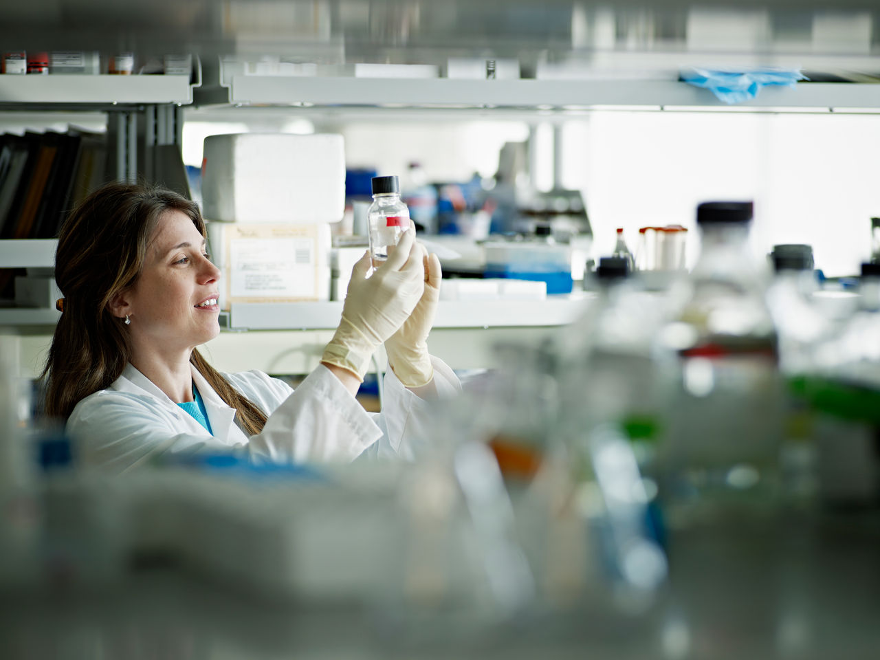 Female scientist examining bottle in research lab