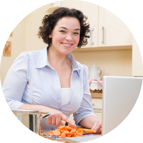 Woman preparing healthy meal in front of her laptop
