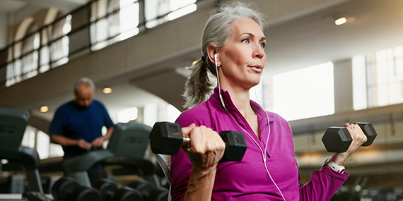 Senior woman lifting weights at the gym