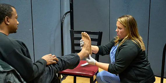 A ChristianaCare caregiver examines a man's foot
