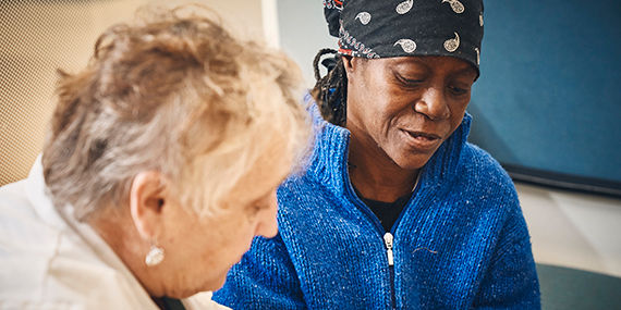 A medical provider performs an oral cancer screening on a patient