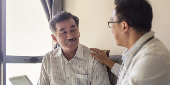 Doctor consoling member of family