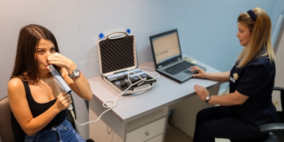 Young woman performing pulmonary function test
