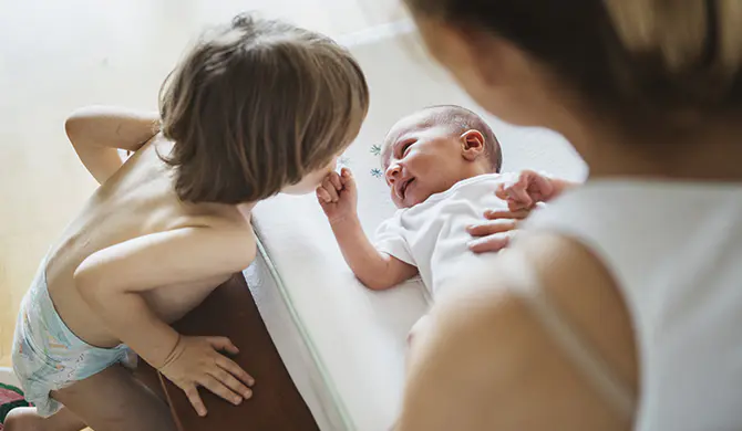 Older brother looking at his new born sibling