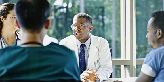 Male doctor leading medical team meeting 