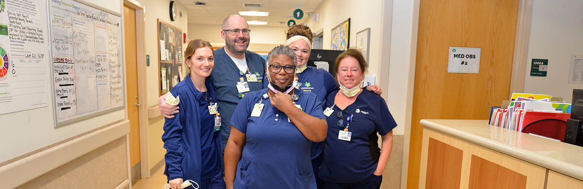 A group of ChristianaCare nurses stands together smiling at the camera