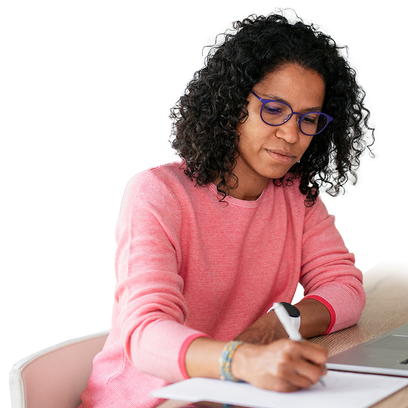 Woman sits at table taking notes