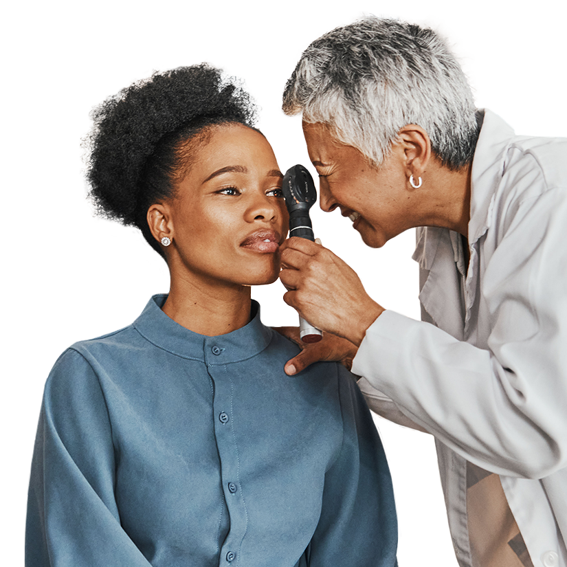 A young Black woman has her eye examined by an optometrist