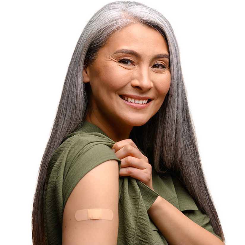 A woman rolls up her sleeve to show a band-aid on her arm