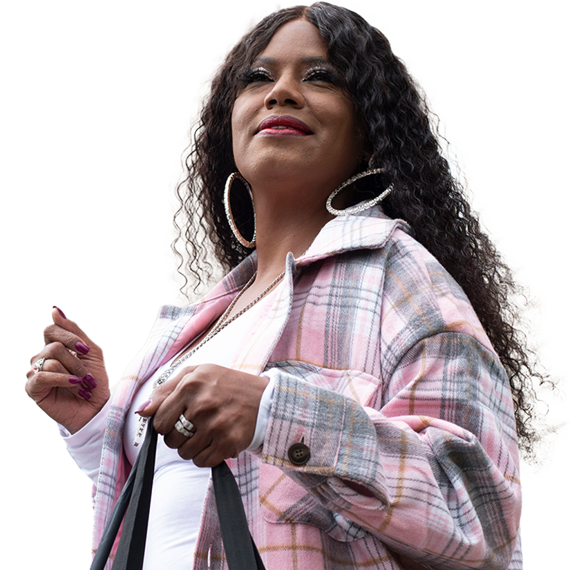 A Black woman holds a bag while looking off into the distance
