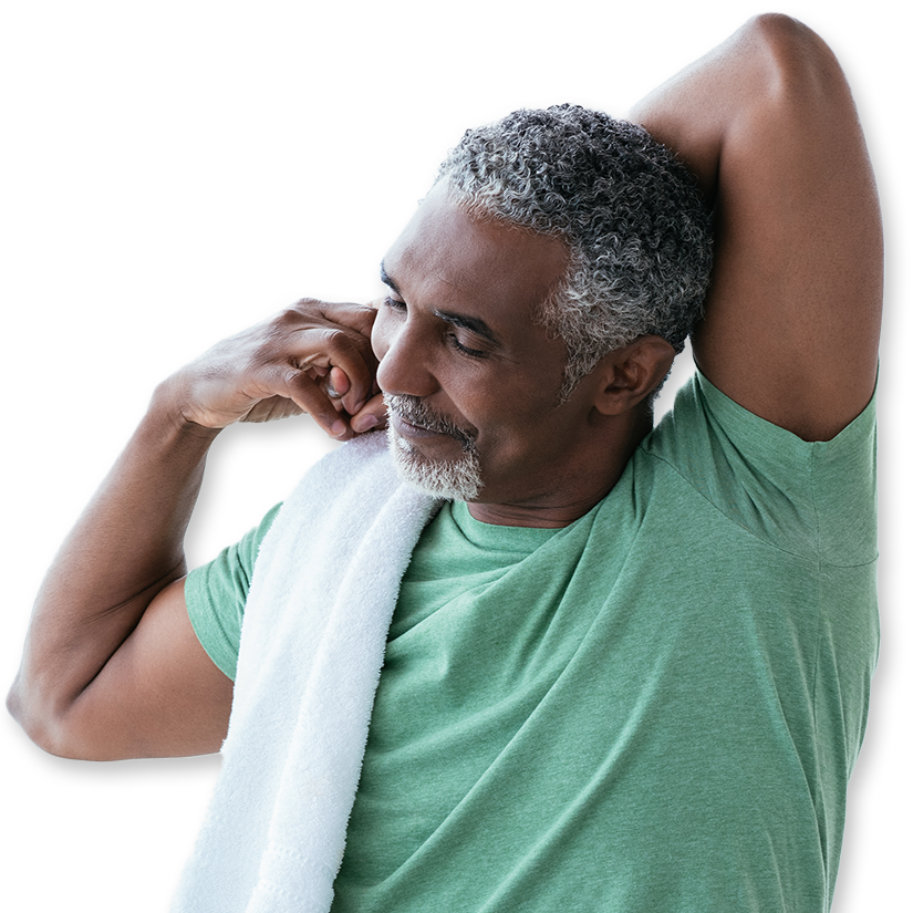 A man stretches with a towel on his shoulder before exercising
