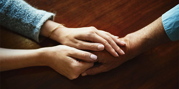 A closeup of a man and woman holding hands