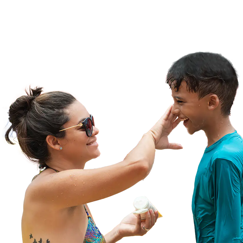 A woman applies sunblock to a child's face