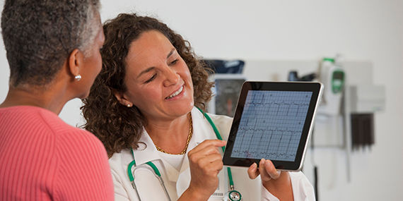 Un médico muestra los resultados de las pruebas de un paciente en una tableta digital