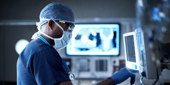 Cirujano mirando la pantalla de la computadora en el quirófano