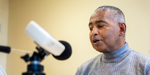 Un hombre que habla con un micrófono como parte de un ejercicio de terapia del habla.