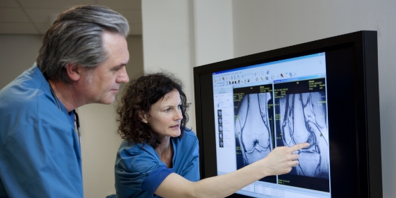 Médicos que observan una IRM de rodilla