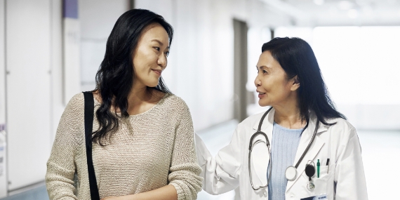 Un médico sonriente que habla con una mujer en el hospital 