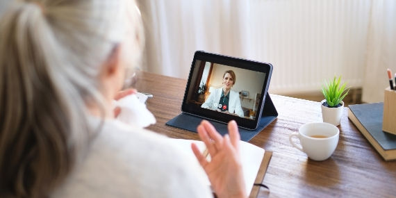 Mujer hablando con un médico con un dispositivo tipo tableta