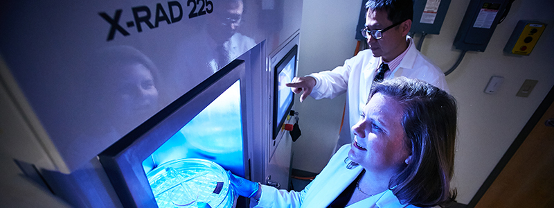 La Dra. Sims-Mourtada aplica radiación a un espécimen de investigación sobre el cáncer en ChristianaCare