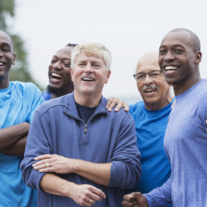 group of men standing together, smiling, supporting one another.