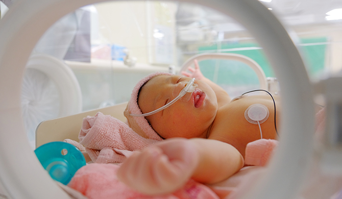 Sleeping newborn in hospital bed