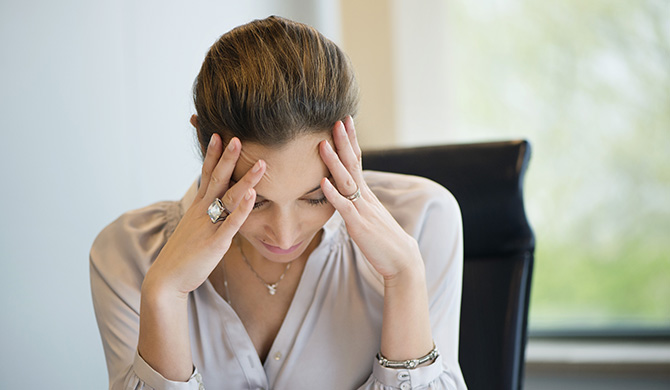 Businesswoman suffering from a headache in an office