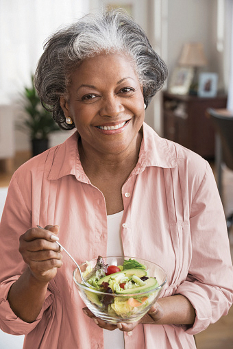 A lady eating a healthy salad.