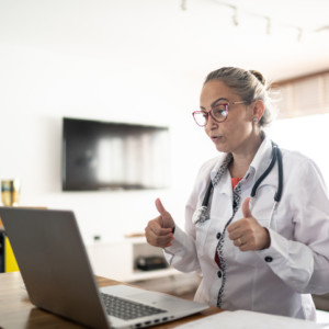 doctor chatting on computer showing thumbs up