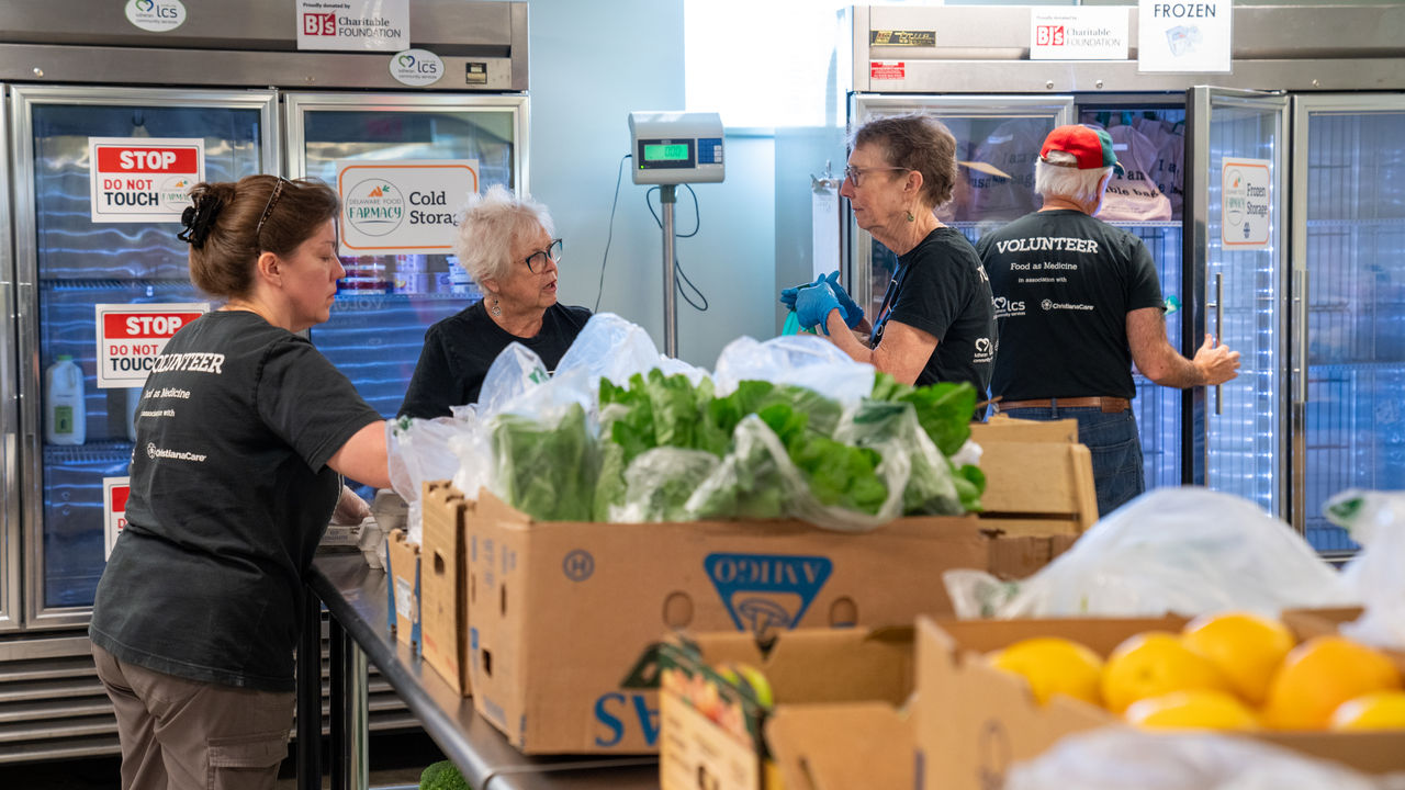 Volunteers organizing fresh produce in pantry
