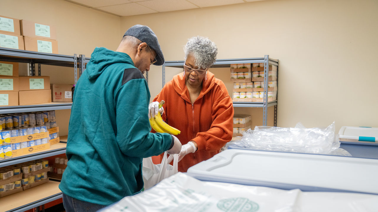 Two community health workers bag groceries to be given to the community