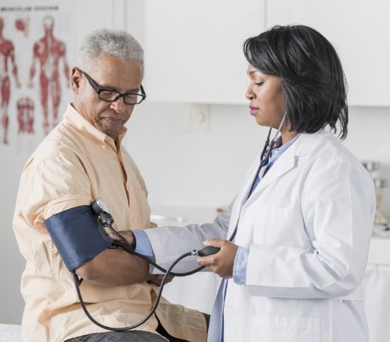 Doctor checking senior man's blood pressure