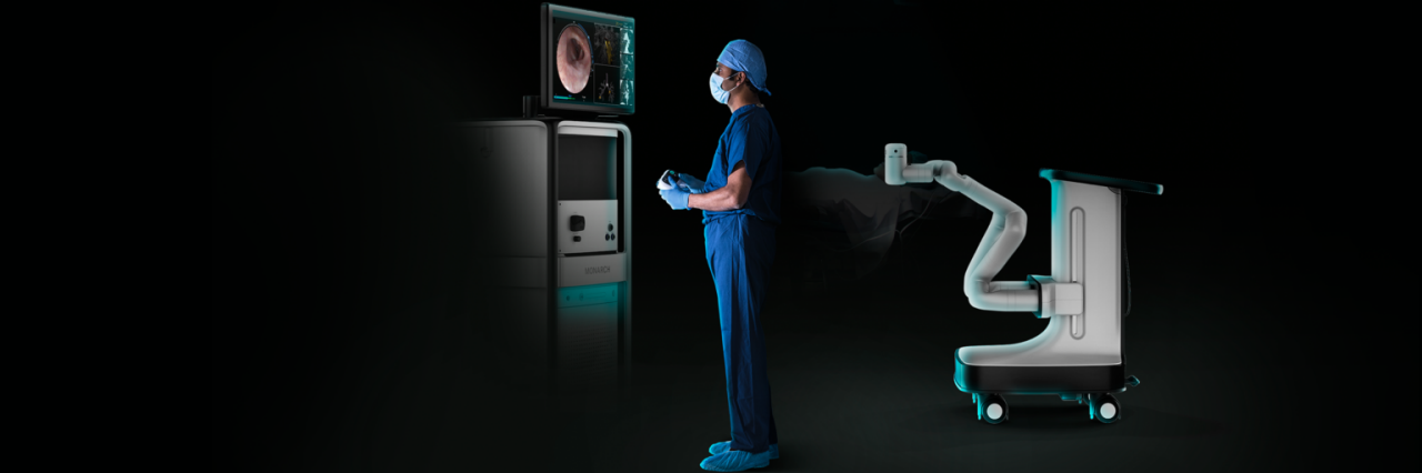 A doctor controls a robotic surgery device while looking at a computer screen
