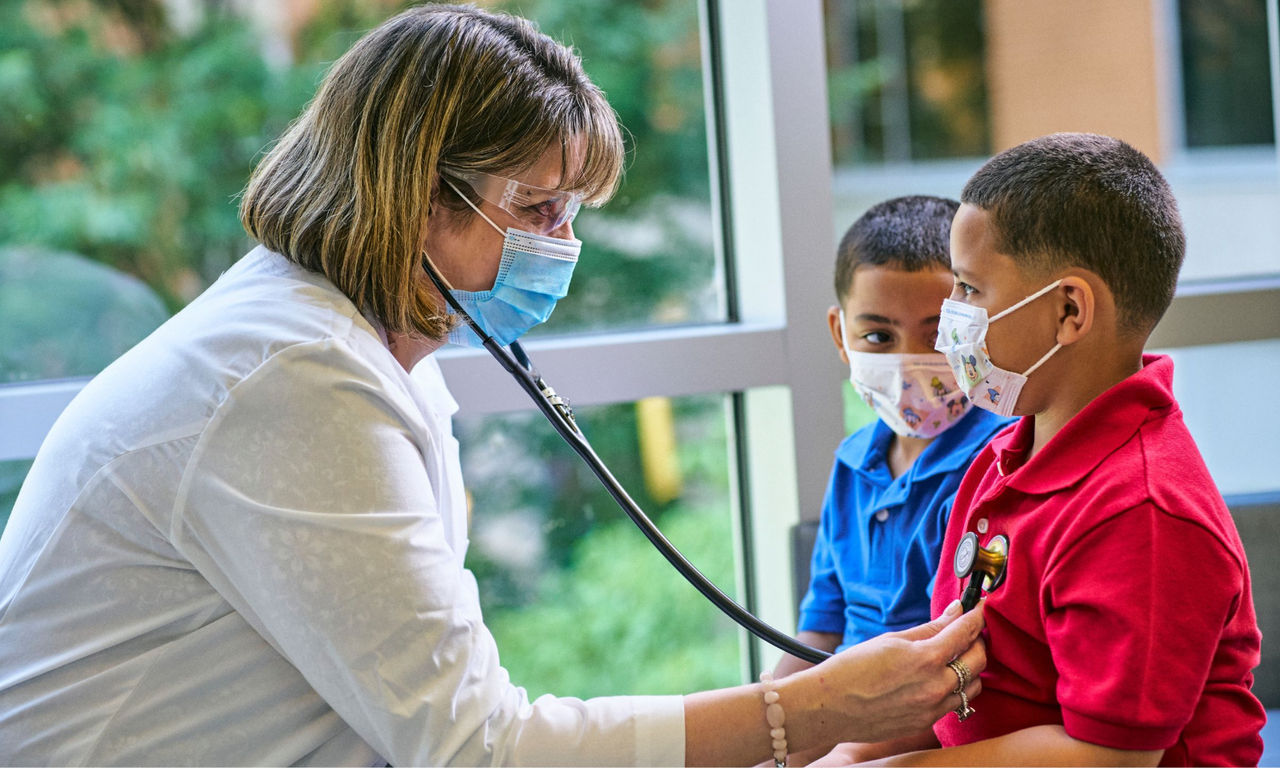 A Primary Care provider examining a patient using a stethoscope