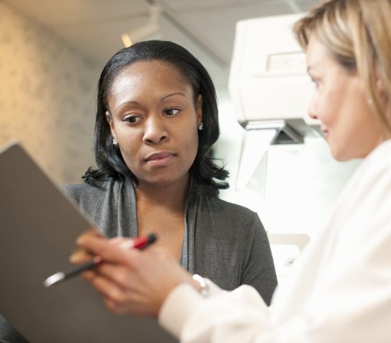 Nurse with patient signing consent for mammogram