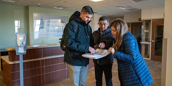 Planners study blueprints for ChristianaCare West Grove Campus during an on-site visit