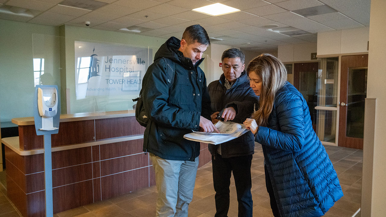 Planners study blueprints for ChristianaCare West Grove Campus during an on-site visit