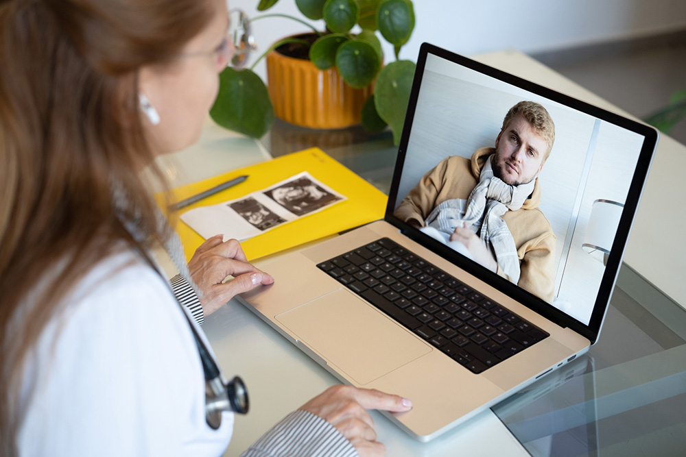 Female doctor giving advice to patient online through video call, using laptop. Wireless technology and medicine concept