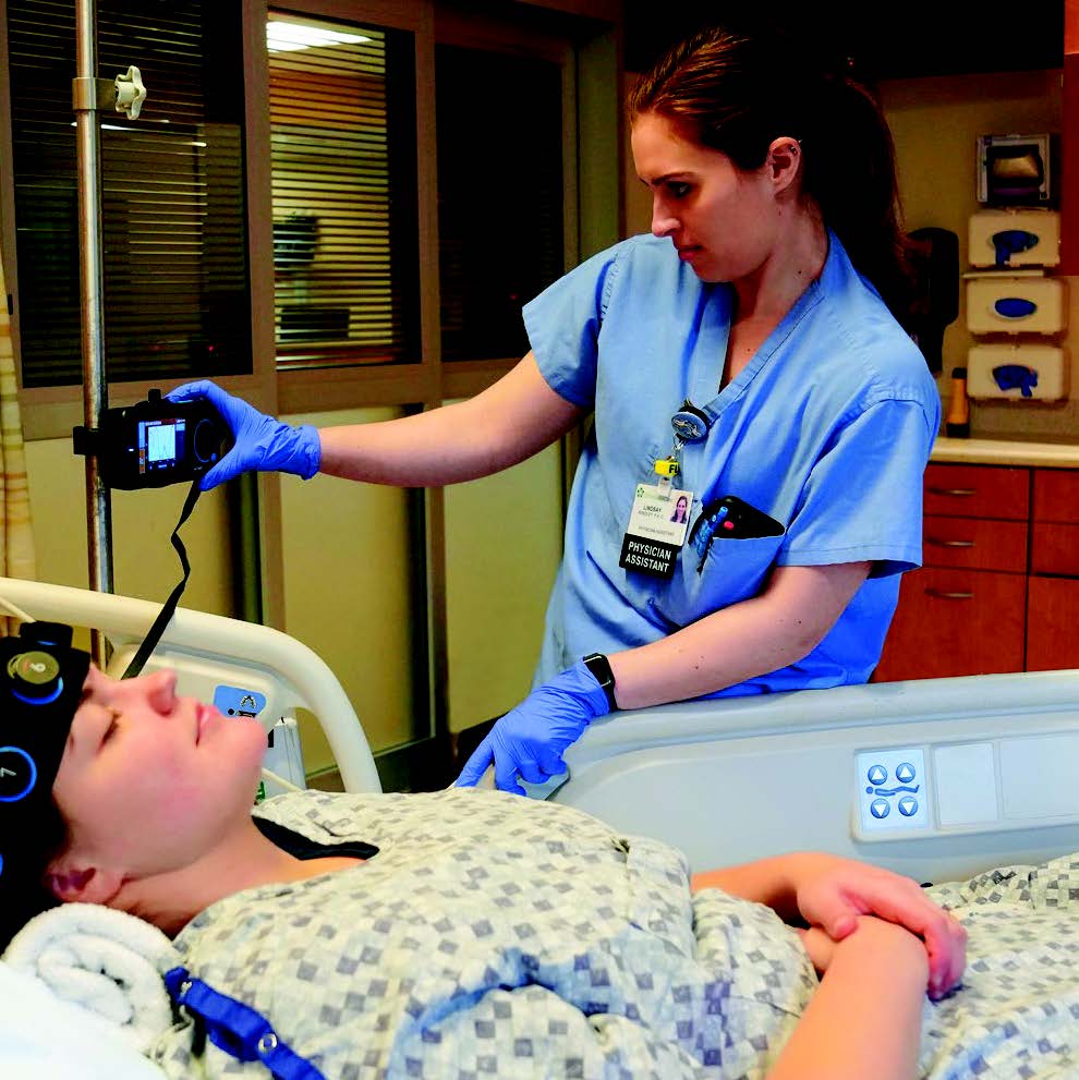 A ChristianaCare neurologist uses Ceribell EEG on a patient in a hospital bed