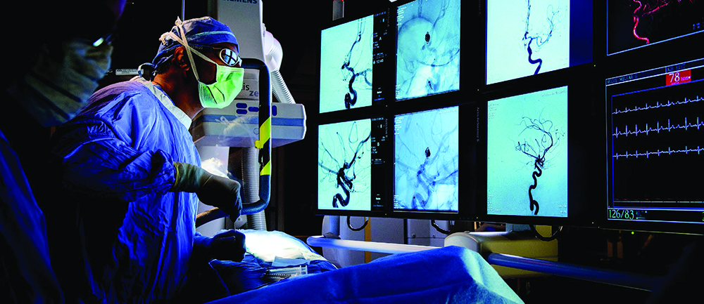 Doctors examine computer screens while performing an operation