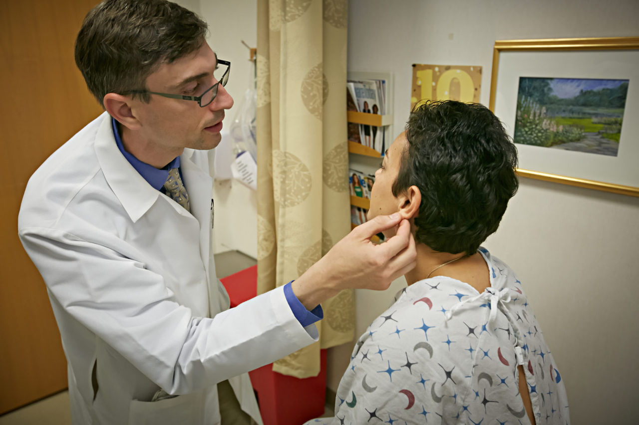médico mirando el oído de un paciente